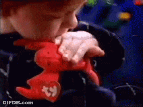 A Child Is Holding A Stuffed Animal With A Beanie On It . GIF
