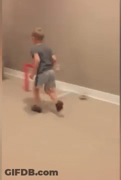 A Child Is Jumping In The Air Near A Basketball Hoop In A Room GIF