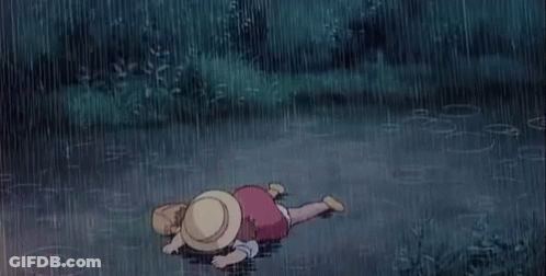 A Child Is Laying On The Ground In The Rain . GIF