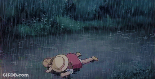 A Child Is Laying On The Ground In The Rain GIF