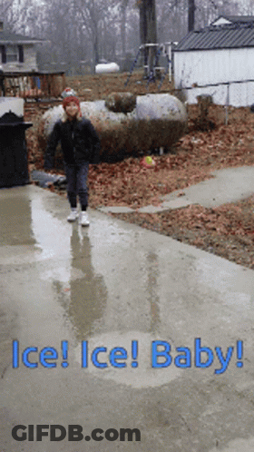 A Child Is Walking Down A Wet Sidewalk With The Words Ice Ice Baby GIF