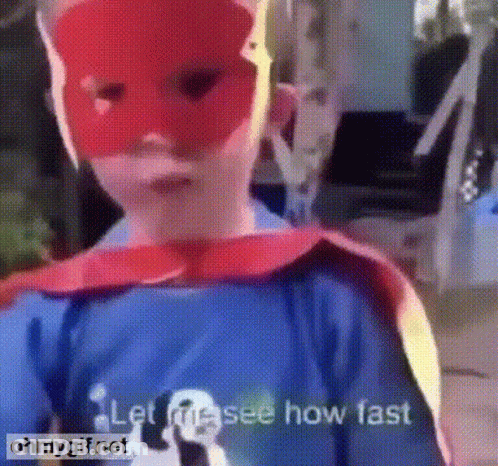 A Child Is Wearing A Red Mask And A Cape And Says Let Me See How Fast GIF