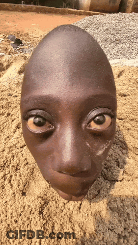 A Child 'S Head Is Buried In Sand And Looks Like An Egg GIF