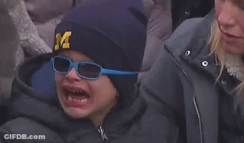 A Child Wearing A Hat With The Letter M On It Is Crying GIF