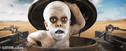 A Child With White Paint On His Face Is Sticking Out Of A Hole In The Ground GIF