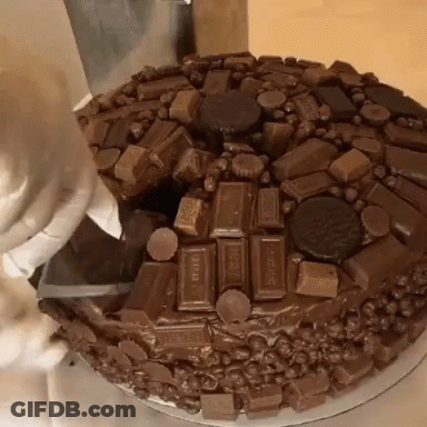 A Chocolate Cake Is Being Decorated With Hershey Candy Bars GIF
