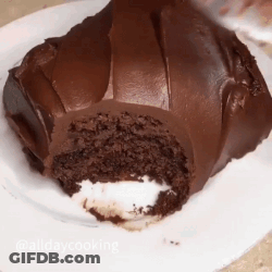 A Chocolate Cake With A Bite Taken Out Of It GIF