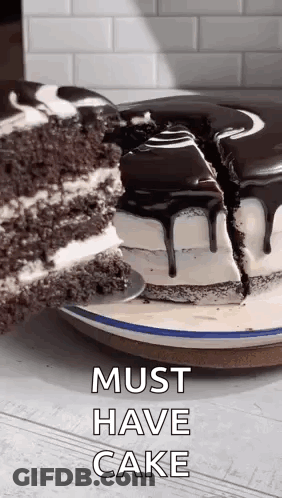 A Chocolate Cake With A Slice Taken Out Of It And The Words `` Must Have Cake '' Written On It . GIF