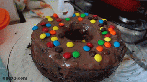 A Chocolate Cake With M & M 'S And A Number 5 On Top GIF
