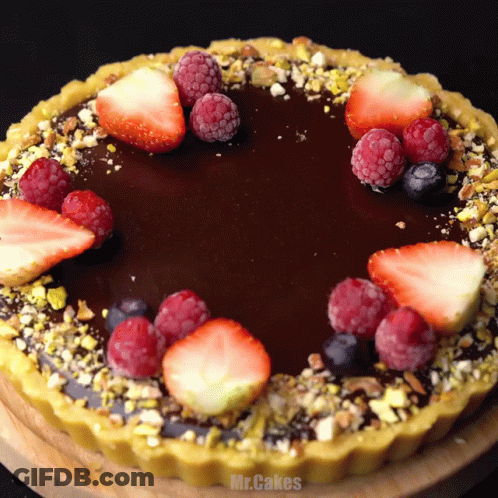 A Chocolate Cake With Strawberries Raspberries And Blueberries GIF