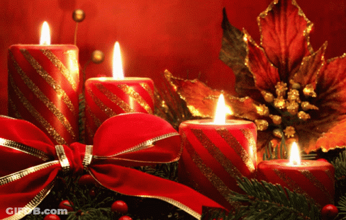 A Christmas Decoration With Candles And A Bow GIF