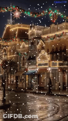 A Christmas Scene With Snow Falling In Front Of A Building GIF