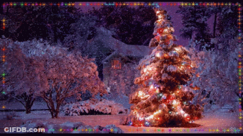 A Christmas Tree Is Lit Up In Front Of A Snowy House GIF