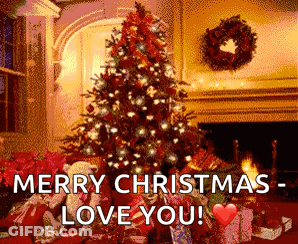 A Christmas Tree Is Sitting In Front Of A Fireplace In A Living Room . GIF