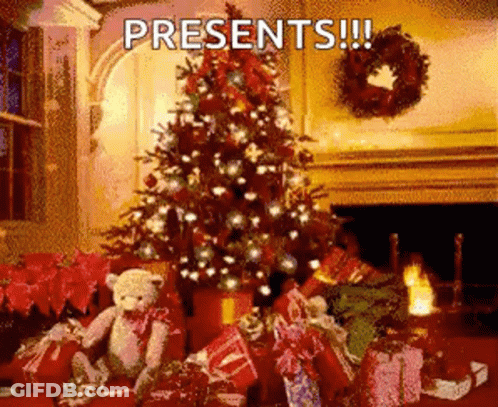 A Christmas Tree Is Surrounded By Presents And A Teddy Bear GIF