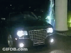 A Chrysler Car Is Parked At Night With Its Headlights On GIF