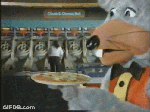 A Chuck E Cheese Mascot Is Holding A Pizza On A Tray . GIF