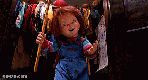 A Chucky Doll Is Holding A Bat In A Closet And Smiling . GIF