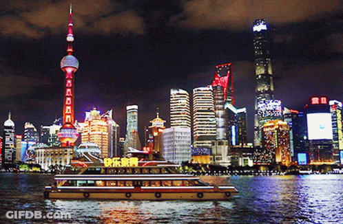 A City Skyline At Night With A Boat In The Foreground That Says ' Happy New Year ' On It GIF