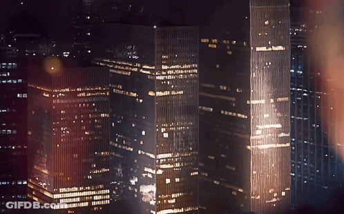 A City Skyline At Night With A Few Buildings Including One That Says ' A ' On The Top GIF