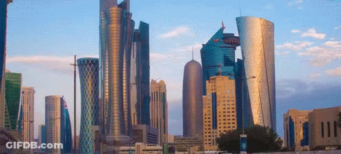 A City Skyline With A Blue Sky And A Few Clouds In The Background GIF