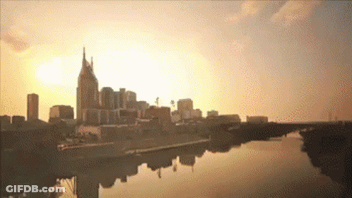 A City Skyline With A River In The Foreground GIF