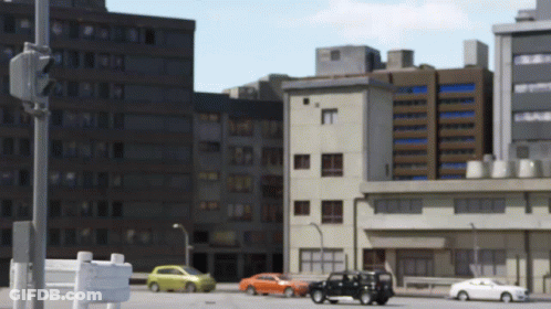 A City Street With Cars And Buildings And A Sign That Says No Parking GIF