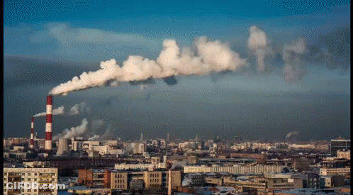 A Cityscape With Smoke Coming Out Of A Factory GIF