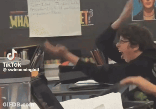 A Classroom With A Sign That Says What GIF