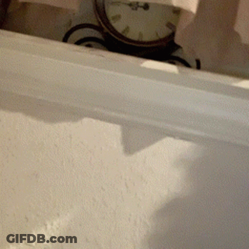 A Clock On A White Wall Shows The Time As Almost 5:00 GIF