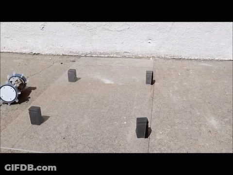 A Clock Sits On A Concrete Surface Next To A Few Bricks GIF
