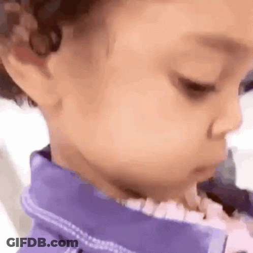 A Close Up Of A Baby 'S Face Wearing A Purple Shirt . GIF
