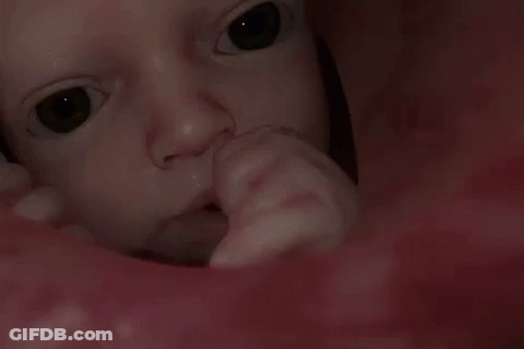 A Close Up Of A Baby 'S Face With A Person 'S Finger In It GIF