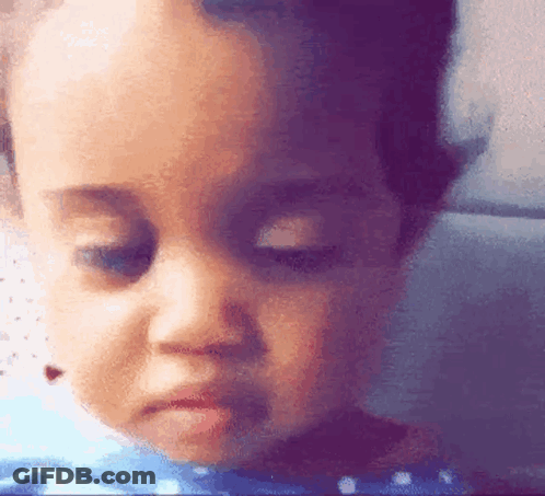 A Close Up Of A Baby 'S Face With A Sad Look On His Face GIF