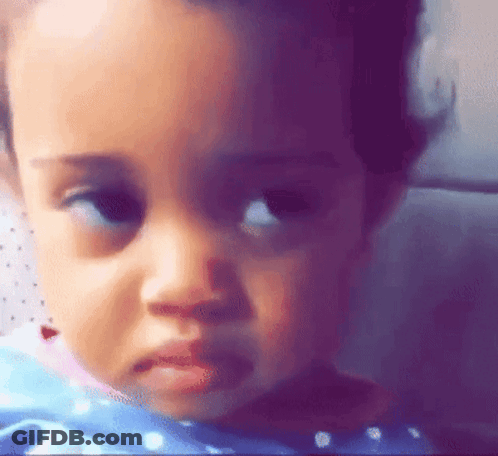 A Close Up Of A Baby 'S Face With A Sad Look On It . GIF