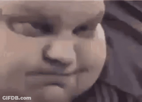 A Close Up Of A Baby 'S Face With A Serious Look On His Face . GIF