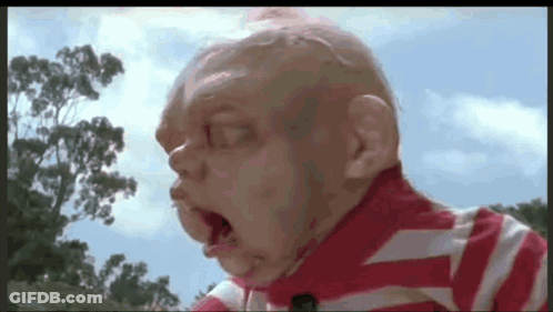 A Close Up Of A Baby 'S Face With A Striped Shirt On GIF