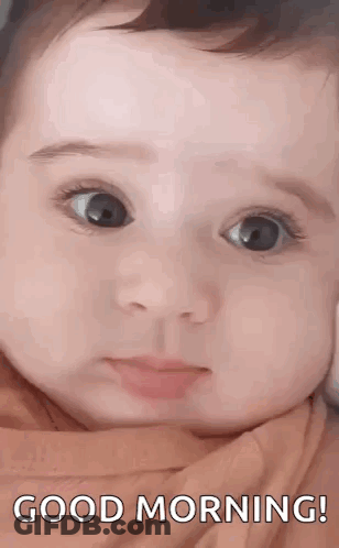 A Close Up Of A Baby 'S Face With The Words `` Good Morning '' Written Above It . GIF