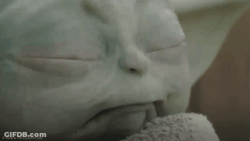 A Close Up Of A Baby Yoda From Star Wars Looking At The Camera GIF