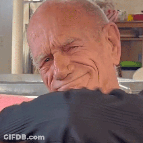 A Close Up Of A Bald Man 'S Face With A Black Shirt On GIF