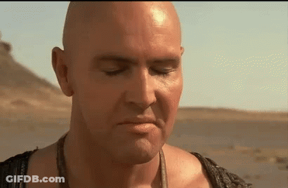 A Close Up Of A Bald Man 'S Face With His Eyes Closed In The Desert . GIF
