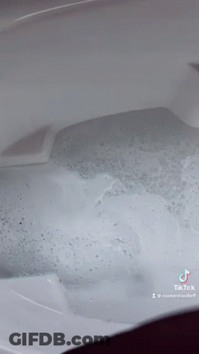 A Close Up Of A Bathtub Filled With Bubbles And Water . GIF