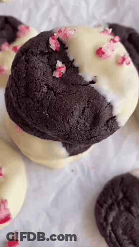 A Close Up Of A Black And White Cookie With Candy Canes On It . GIF