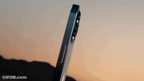 A Close Up Of A Black Apple Phone With A Mountain In The Background GIF