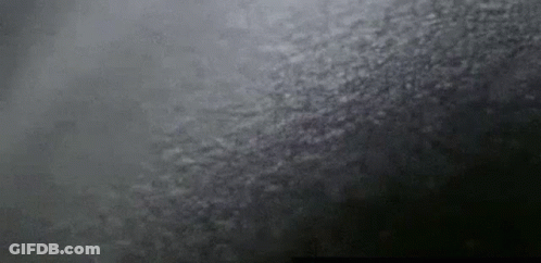 A Close Up Of A Black Background With A Gray Texture And A Few White Clouds . GIF