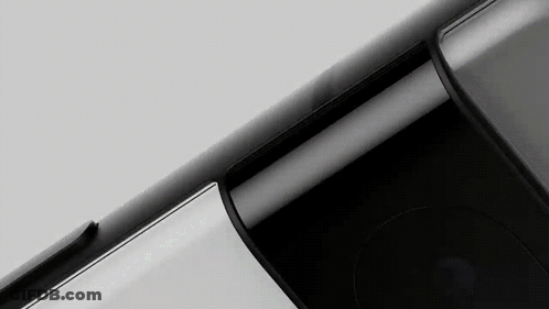 A Close Up Of A Black Cell Phone On A White Surface . GIF