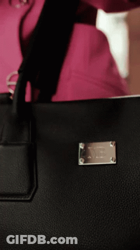 A Close Up Of A Black Purse With A Silver Plaque That Says ' X ' On It GIF