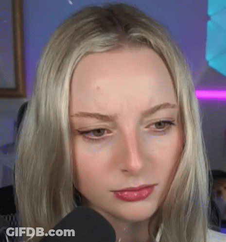 A Close Up Of A Blonde Woman 'S Face With A Microphone In Front Of Her . GIF