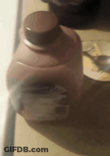A Close Up Of A Bottle Of Milk With A Spoon In It GIF