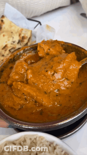 A Close Up Of A Bowl Of Curry With A Spoon In It GIF